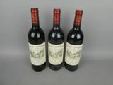 trois bouteilles de vin rouge posées côte à côte sur une table