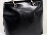 black leather handbag with metal handles on a white background