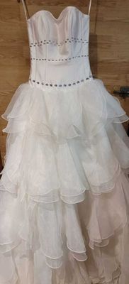 a white dress hanging on a hanger in a room