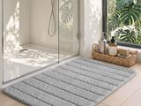 un tapis de bain posé par terre devant la douche