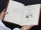 une personne tient un livre dans ses mains, posée sur une surface noire
