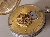a close up of a pocket watch on a table