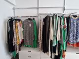 a closet with a lot of clothes hanging on a rail