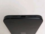 the back of a black cell phone sitting on top of a white table