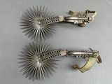 pair of silver - plated metal hair clips with starbursts