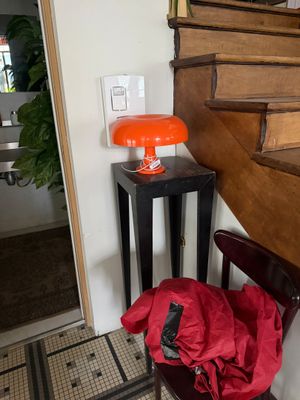 un sac rouge posé sur une chaise devant un escalier