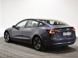the back of a gray tesla model 3 parked on a checkered floor