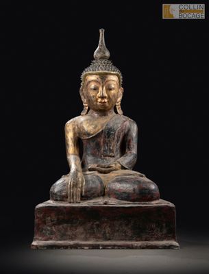une statue de Bouddha assis sur un bloc de bois
