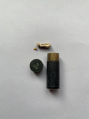 un petit briquet et une pièce de monnaie posés sur une surface blanche