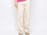 a man in a pink shirt and khaki pants posing for a picture