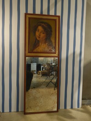 une photo d'un tableau accroché au mur à côté d'un miroir