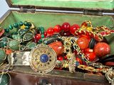 a wooden box filled with assorted jewelry on a table