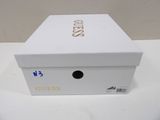 white box with gold lettering on it sitting on a white table
