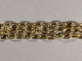 a close up of a gold chain bracelet on a white surface
