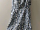 une robe bleue et blanche suspendue à un cintre