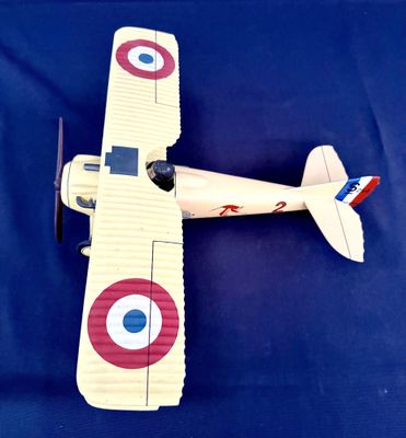 une petite maquette d'avion posée sur une surface bleue