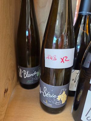 several bottles of wine are on a shelf with labels on them