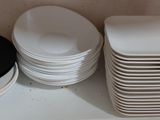 a stack of plates and bowls on a shelf in a kitchen