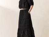 the woman is wearing a black dress and sandals