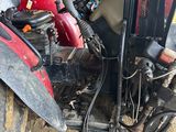 a red and black motorcycle parked in a garage
