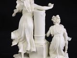 a figurine of a woman and a man on a pedestal