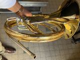 a man that is holding a brass instrument in his hand