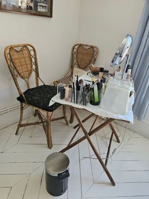 une table avec un miroir et une chaise dans un coin de la pièce