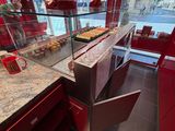 un comptoir avec une tasse de café et une vitrine de viennoiseries
