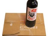 a bottle of red wine sitting on top of a cardboard box