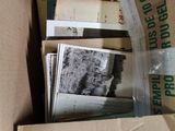 a cardboard box full of old photos and other items