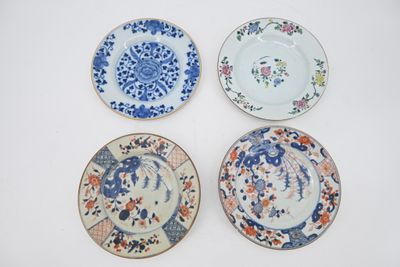 quatre assiettes à motifs différents posées sur une surface blanche
