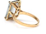 a close up of a gold ring with a blue topaz stone