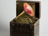 une petite boîte en bois contenant une corne rouge et dorée