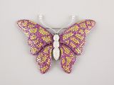 un gros plan d'une broche en forme de papillon sur fond blanc
