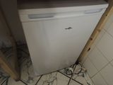 a small white dishwasher in the corner of a kitchen