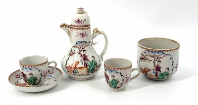 four cups and a teapot sitting on a table