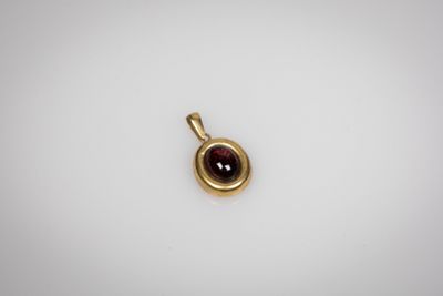 un pendentif en or jaune orné d'une grenat au centre