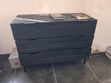 a black chest of drawers in a room with tile flooring