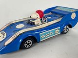 a blue toy car with a snoop bear in the back