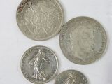 four different british coins sitting on top of each other on a white surface
