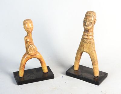 pair of wooden figurines of a man and a woman on black bases