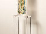 a glass sculpture on a stand in the corner of a room
