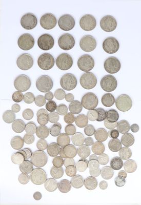 some silver coins are scattered on a white surface