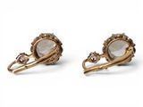 a pair of gold tone earrings with a faceted stone