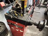 a cat sitting on top of a machine in a garage