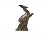 une image représentant une statue en bronze d'un cerf posée sur une souche d'arbre