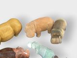 five wooden animals sitting in a circle on a white surface