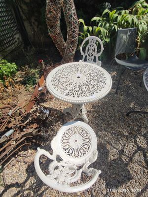 a white table and two chairs in a garden