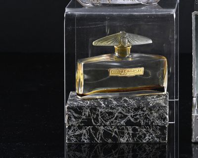 a glass perfume bottle with a bird on top of it