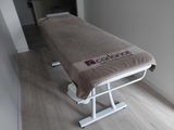 une table de massage recouverte d'une serviette, dans une pièce